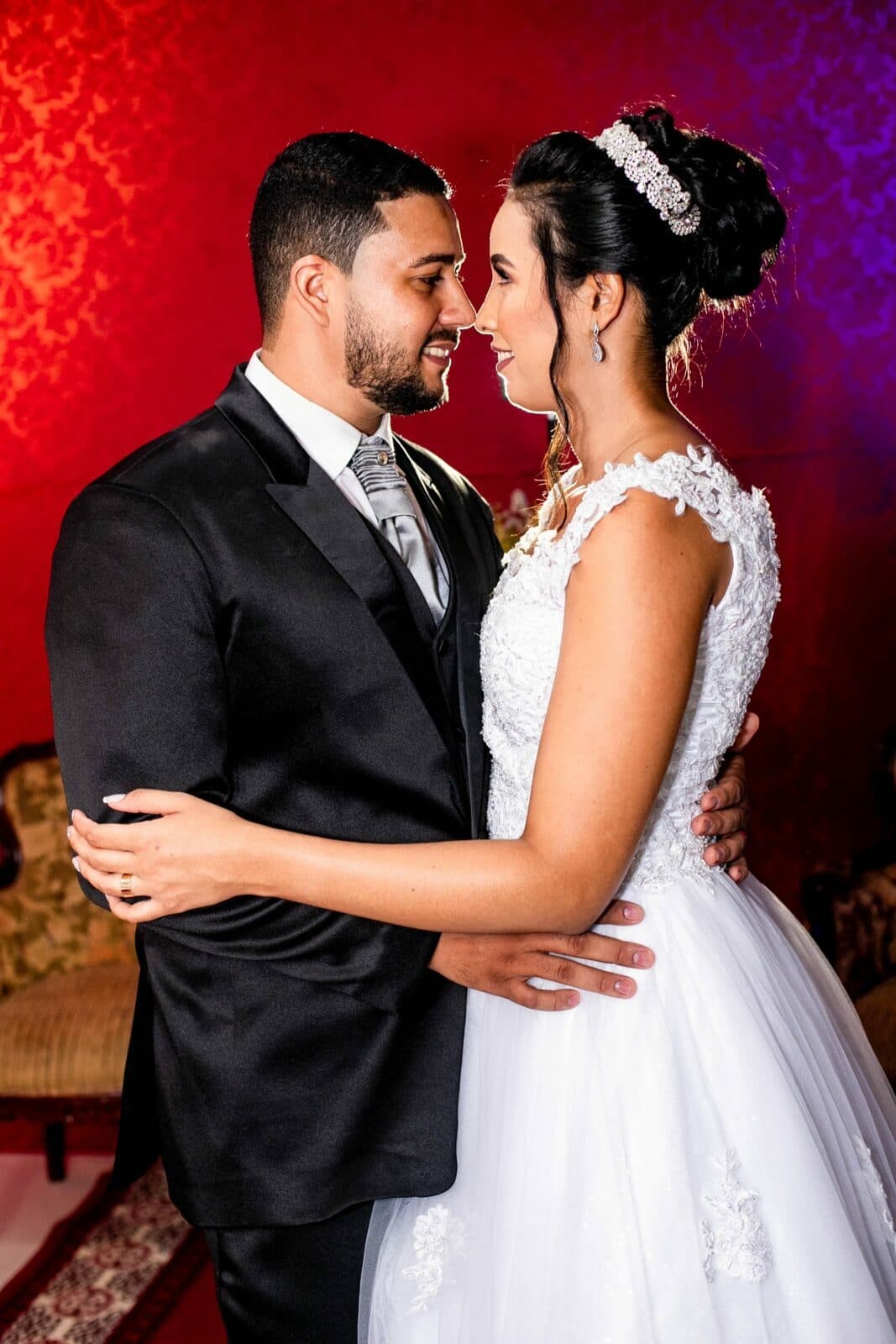 Casal abraçado, olhando um para o outro na celebração.
